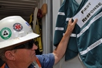 Batch plant Superintendent Rich Hamilton's hard hat bears both the original first responders' logo (left) and the current emblem. The stickers indicate authorization to be at an incident site; all others must stay clear.
