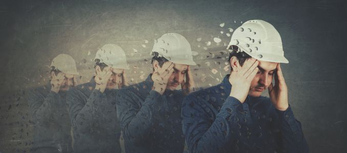 Man in Hard Hat Holding Head