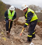 Workers prepare to install a natural gas residential service line. As a consensus standard for this job category, natural gas repair and installation crews typically use FR outerwear, including coveralls and high-vis vests.