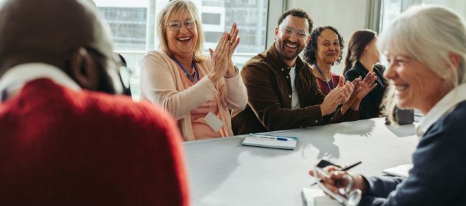 People at a clapping at conference table