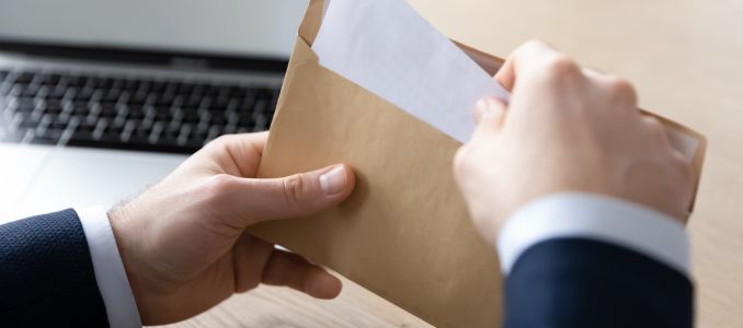 Hands Placing Letter in Envelope
