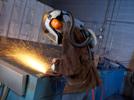A metal shop worker is using the 3M Versaflo Respirator System, which combines respiratory, head, eye and face, and hearing protection.