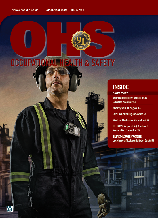 magazine cover of man in blue checkered shirt with yellow and orange vest wearing hearing, eye and hand protection while sanding object