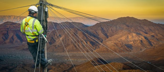 Lone Worker in the Desert on Utility Pole